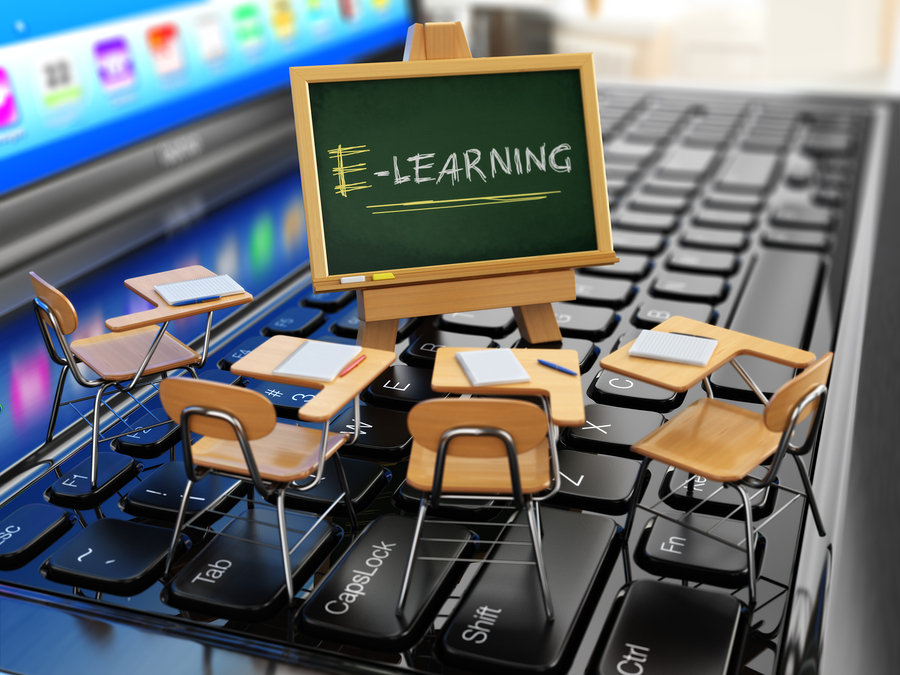 E-learning concept. Schooldesk and chalkboard on the laptop keyboard. 3d